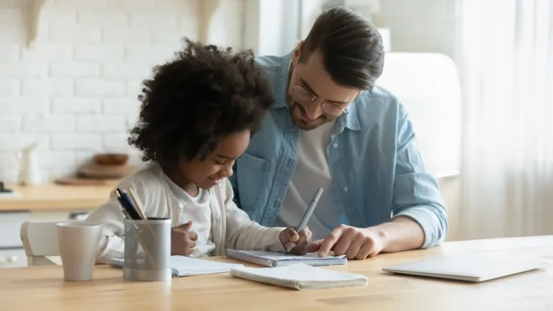 Adult and child working together at table