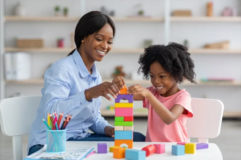 Adult and child building block tower together