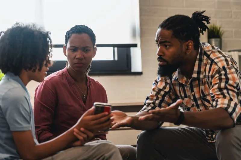 Three people discussing while seated indoors