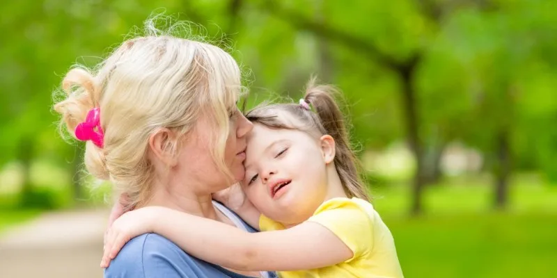 Woman holding young girl outdoors