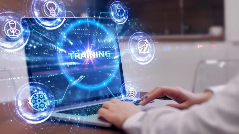 Hands typing on laptop with training graphic
