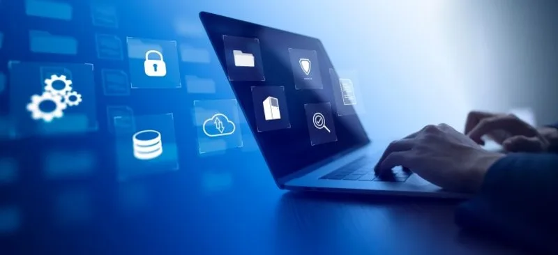 Hands typing on laptop with security icons