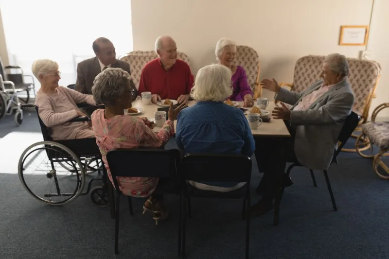 Group of older adults sitting around dining table