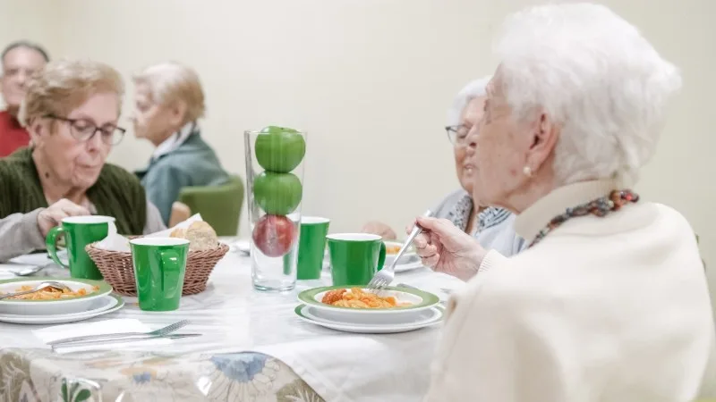 Elderly people eating together at a table