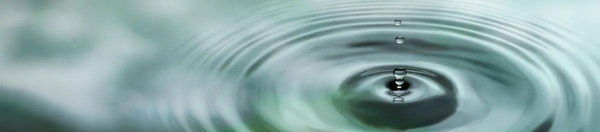 Close-up water droplet creating ripples