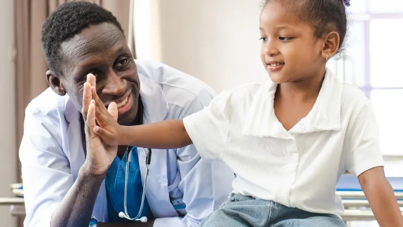 Doctor giving high five to young child