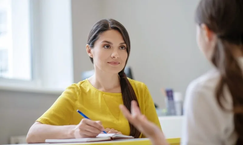 Woman taking notes during conversation