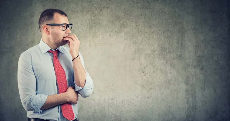 Young man in shirt and tie looking thoughtful