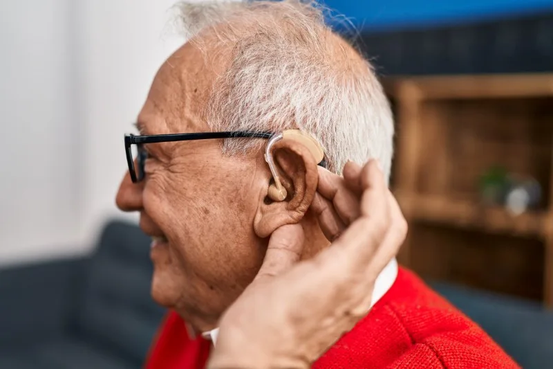Elderly man wearing behind-the-ear hearing aid