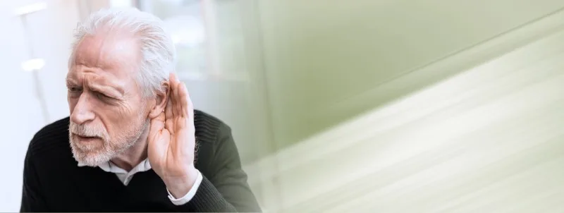 Older man cupping hand to ear listening