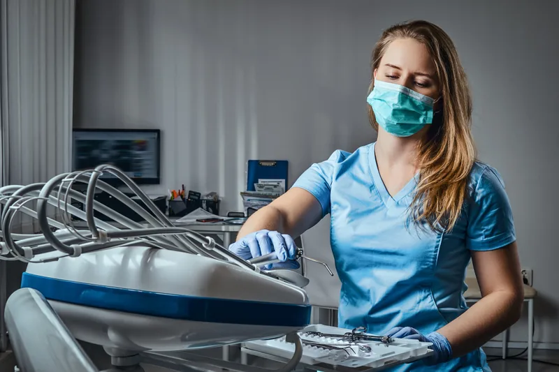 Female dental nurse wearing mask and scrubs