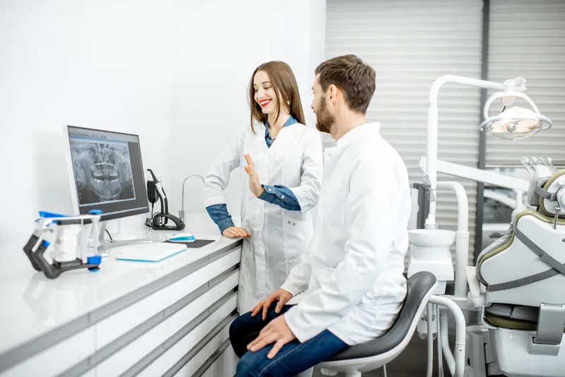 Female dental nurse and male dentist reviewing x-ray