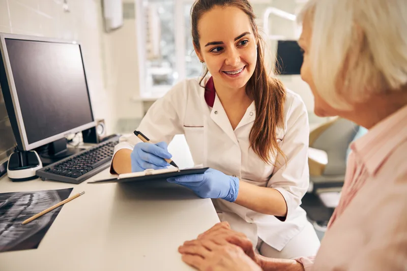 Young female dental nurse consulting older female patient
