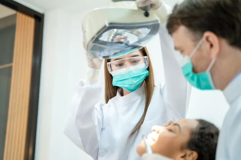 Female dental nurse and male dentist with patient