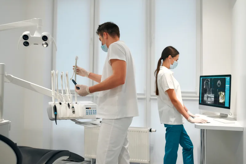 Two masked dental staff working in clinic