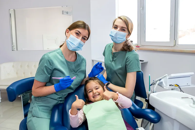 Two female dental nurses with child patient