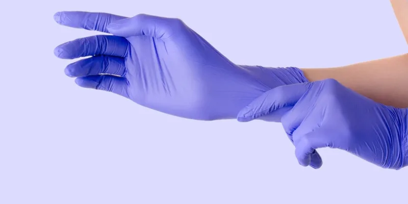 Hands putting on blue nitrile gloves