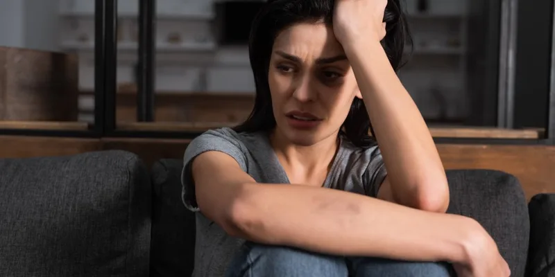 Seated young woman showing arm bruises