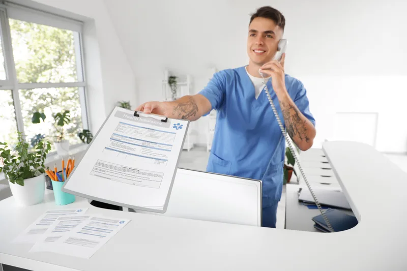 Reception staff taking a phone call at a clinic reception desk