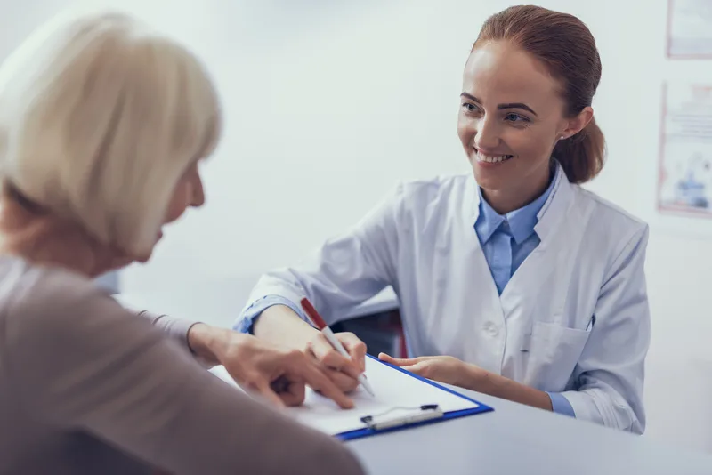 Health professional speaking with a patient at reception