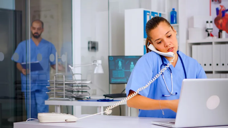 Medical assistant speaking by phone in a clinic