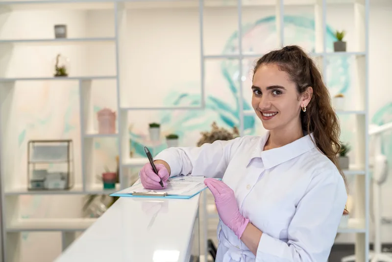 Patient filling out a data card at a medical reception desk
