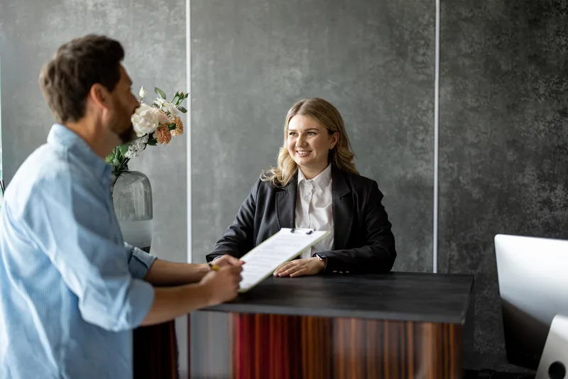 Medical receptionist with man at the reception desk