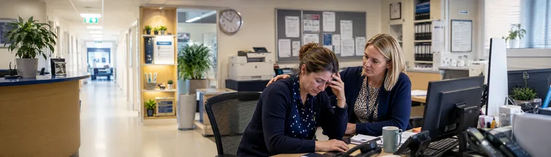 Two female GP receptionists working together