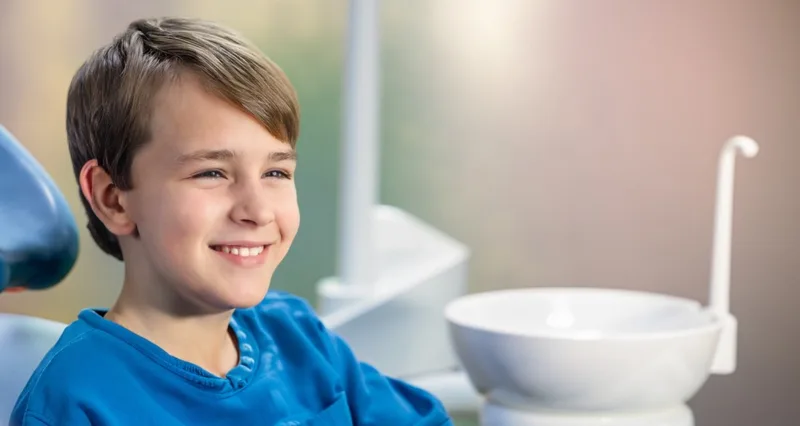 Smiling young boy sitting in dental chair
