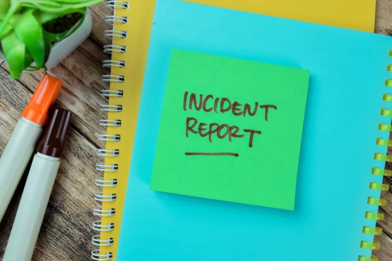 Sticky note reading 'Incident Report' on notebooks