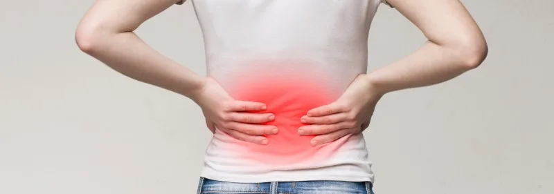 Person holding lower back with red pain overlay