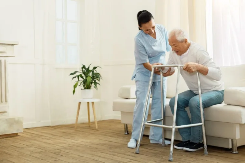 Caregiver assisting an older person with a walker