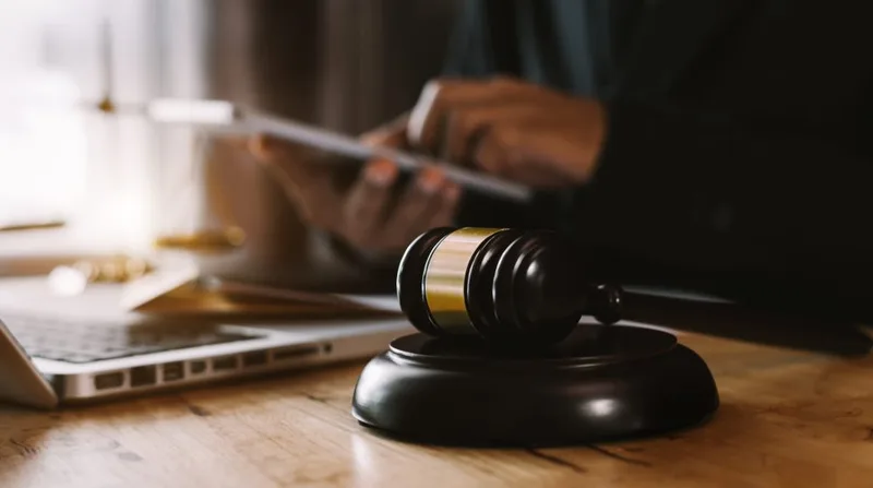 Wooden judge gavel on desk with laptop