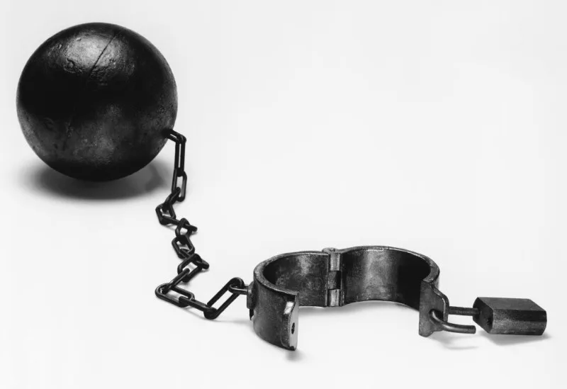 Metal ball and chained shackle on white background