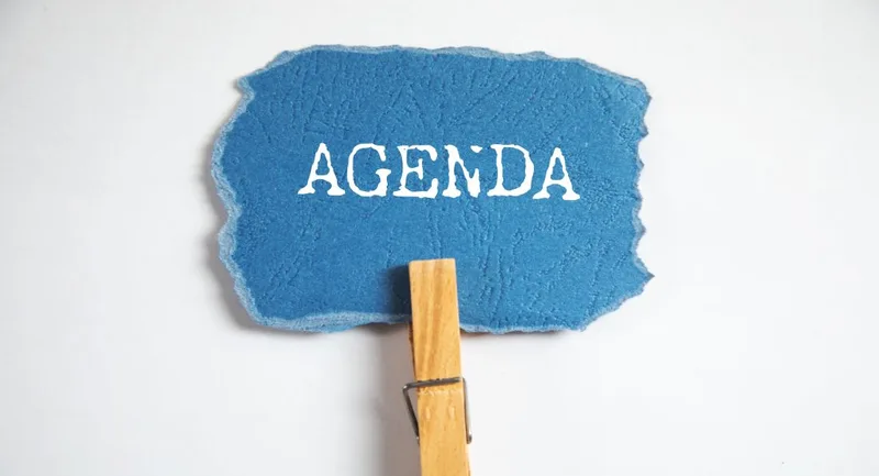 Blue torn paper labelled AGENDA on clothespin