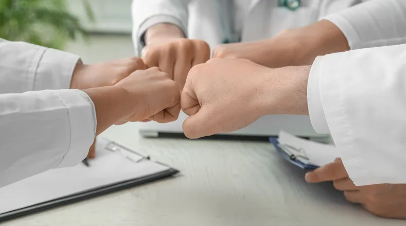 Group fist bump over table