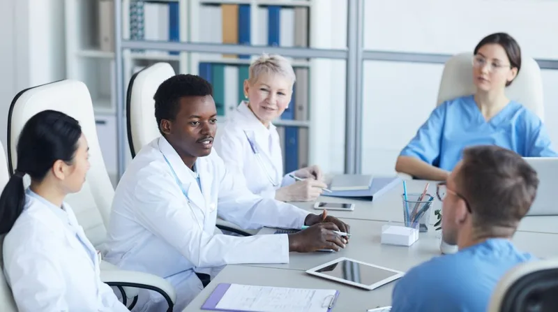 Diverse medical team meeting around conference table