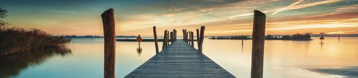 Person meditating beside a calm lake