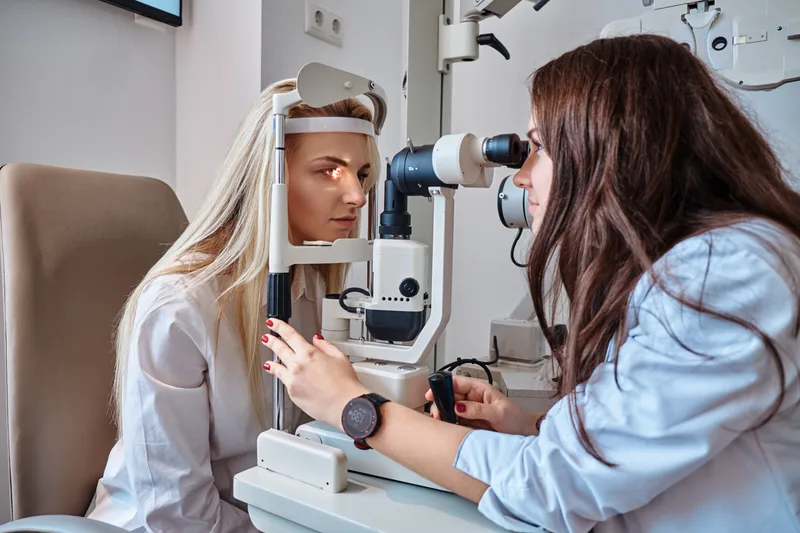 Woman undergoing eye exam with slit lamp