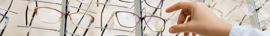 Hand reaching for eyeglasses on display