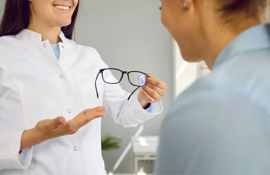 Optical professional listening to a seated customer
