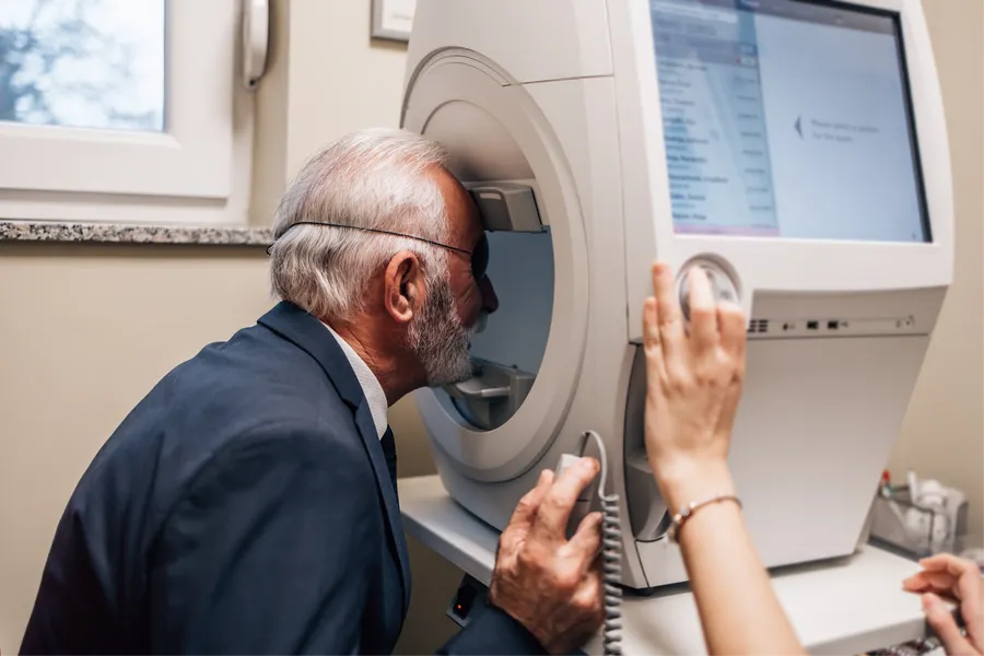 Elderly man undergoing eye test at machine
