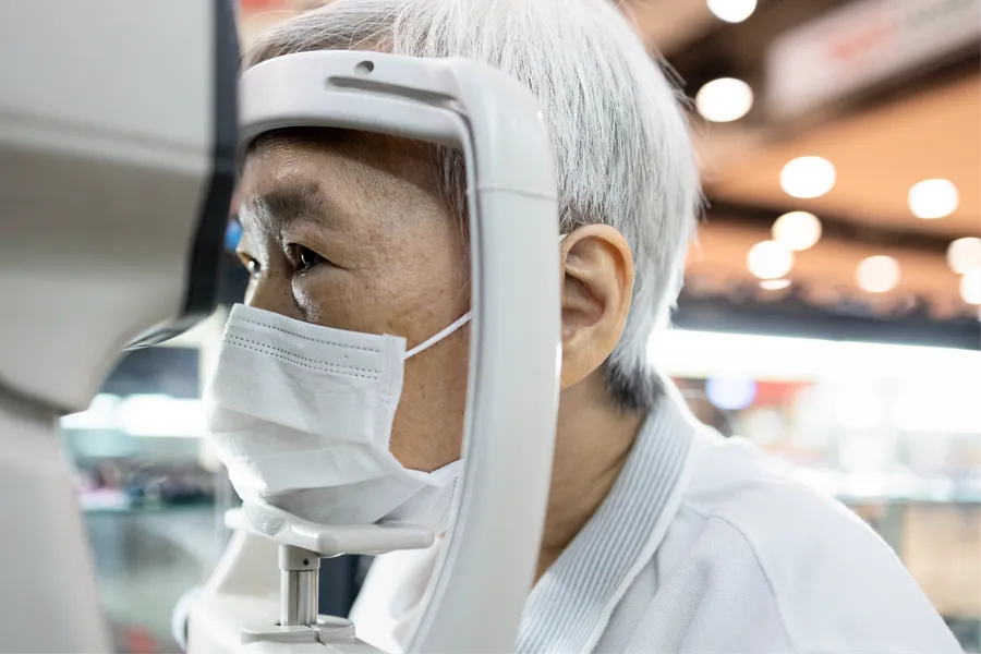Person wearing mask at eye exam machine
