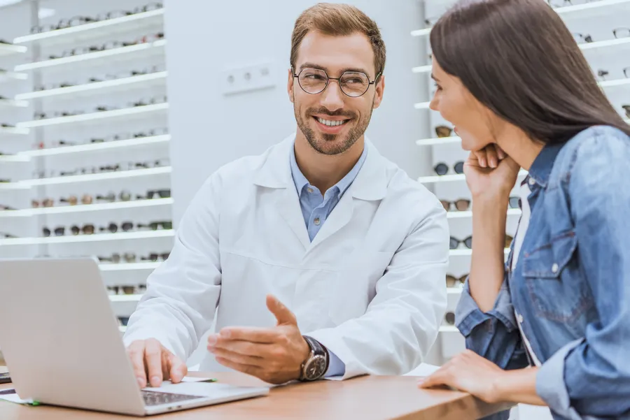 Optician consulting with customer at desk