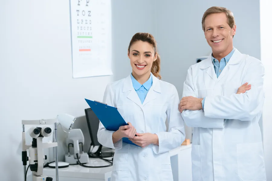Two eyecare professionals in white coats smiling
