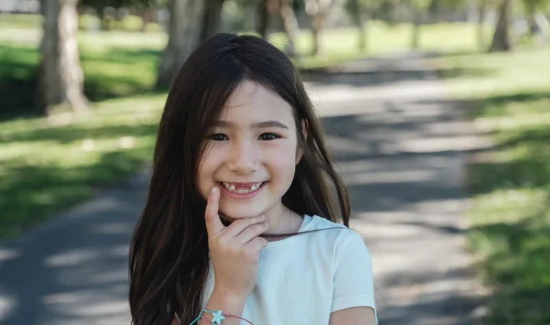 Smiling young girl pointing to her teeth