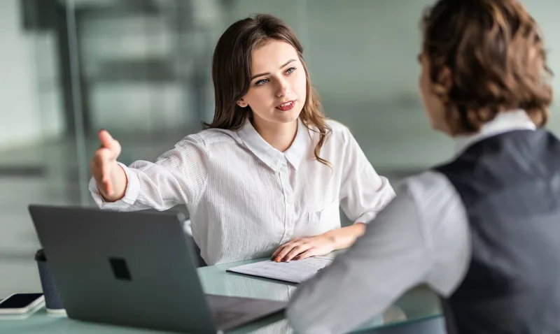 Young woman and man discussing at desk