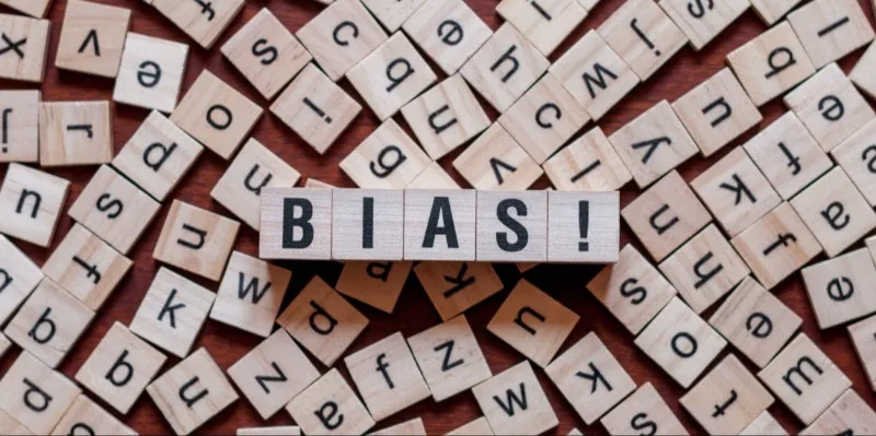 Scrabble tiles spelling BIAS on wooden blocks