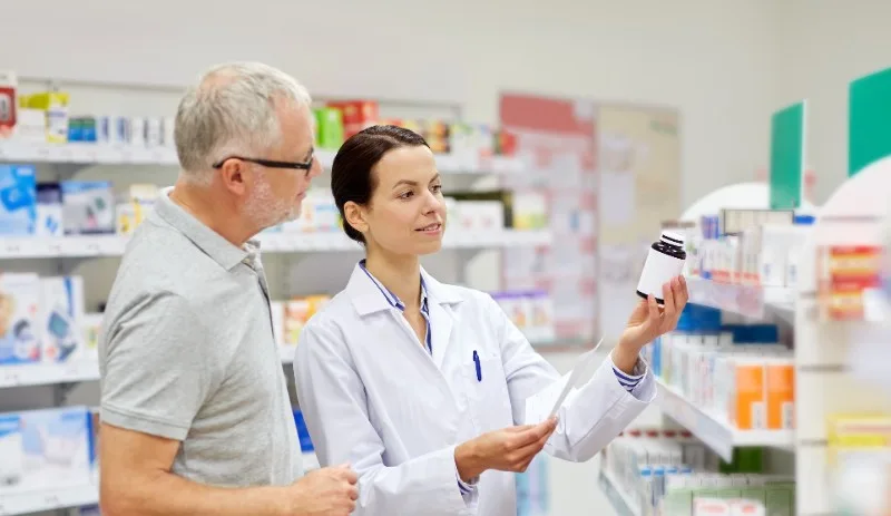 Pharmacist speaking to a patient at the counter