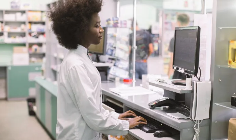 Pharmacy technician working at computer terminal
